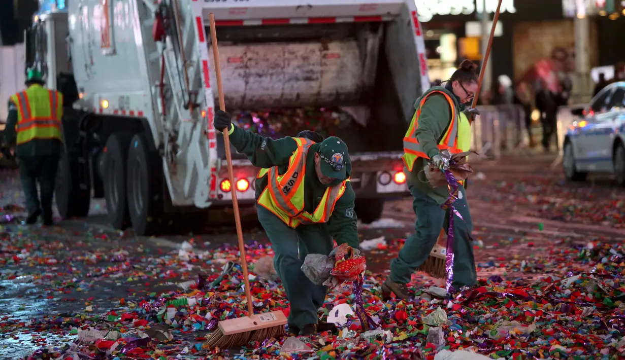 Petugas kebersihan membersihkan sampah yang berserakan di jalan usai perayaan tahun baru 2016 di Times Square di Manhattan borough, New York, USA (1/1/2016). (REUTERS/Andrew Kelly)