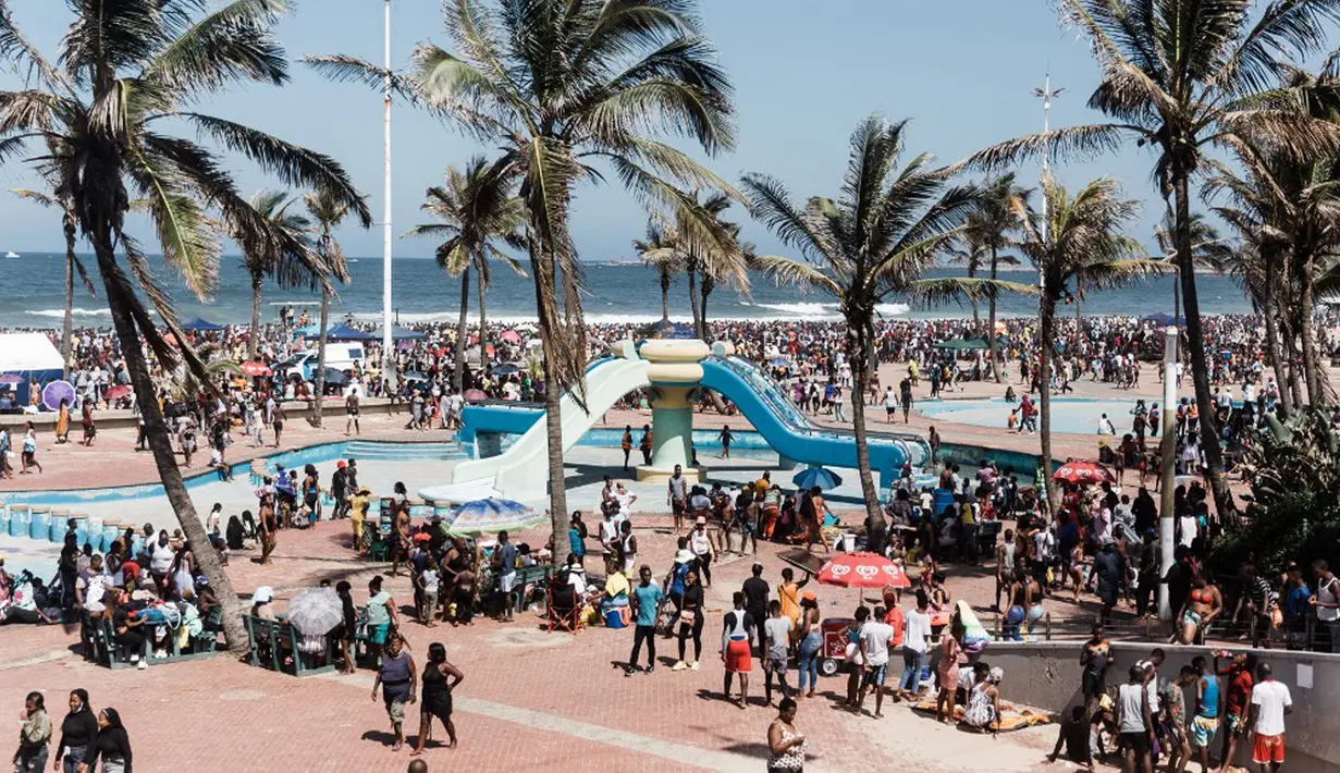 Ribuan wisatawan bersuka ria saat perayaan Tahun Baru di South Beach, Durban, Afrika Selatan, 1 Januari 2022. Menurut polisi Afrika Selatan, hampir 50 ribu orang diperkirakan akan menghabiskan hari di pantai. (Rajesh JANTILAL/AFP)