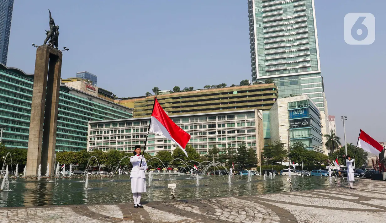 Pasukan pengibar bendera (Paskibra) berbaris membawa bendera Merah Putih di Bundaran Hotel Indonesia (HI), Jakarta, Kamis (15/8/2024). (Liputan6.com/Herman Zakharia)