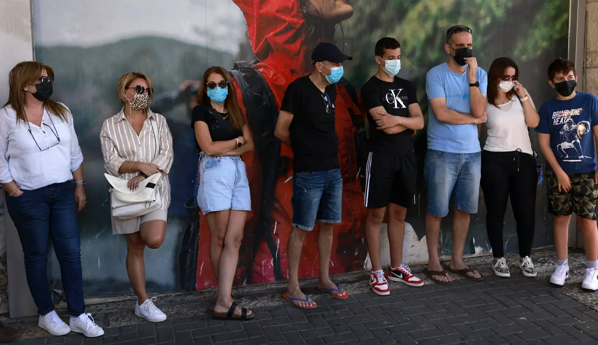 Warga Israel mengenakan masker setelah pihak berwenang memperketat pembatasan untuk mengekang lonjakan Covid-19, di Yerusalem, Kamis (19/8/2021). Pemerintah setempat kembali memperketat perbatasan pada Rabu (18/8) saat Israel mencatat angka infeksi harian tertinggi sejak Januari (MENAHEM KAHANA/AFP)