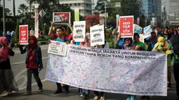 Aktivis membentangkan spanduk berisi tanda tangan warga saat peringatan Hari Tanpa Tembakau di Bundaran HI, Jakarta, Minggu (31/5). Hari Tanpa Tembakau Sedunia diperingati di seluruh dunia setiap tahun pada tanggal 31 Mei. (Liputan6.com/Faizal Fanani)