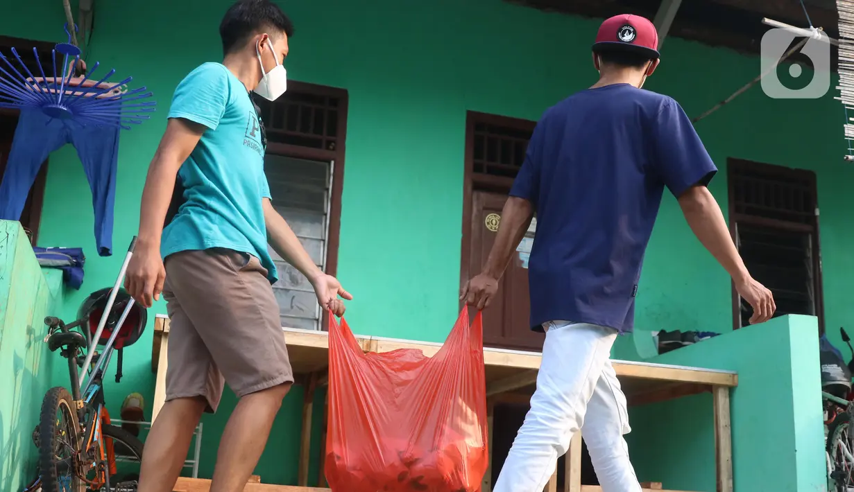 Warga membawa nasi bungkus untuk warga yang terdampak Covid-19 di di RW 03, Kelurahan Gandasari, Kecamatan Jatiuwung, Kota Tangerang, Jumat (11/6/2021).  Dampak penerepan lockdown membuat warga sekitar yang sehat melakukan aksi bersama untuk menyuplai makanan.  (Liputan6.com/Angga Yuniar)