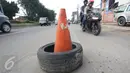 Kendaraan menghindari penanda lubang di Jalan Otista Raya, Jakarta, Rabu (22/2). Kondisi tersebut berbahaya bagi pengguna jalan, khususnya pengendara sepeda motor yang melintas saat malam hari. (Liputan6.com/Immanuel Antonius)