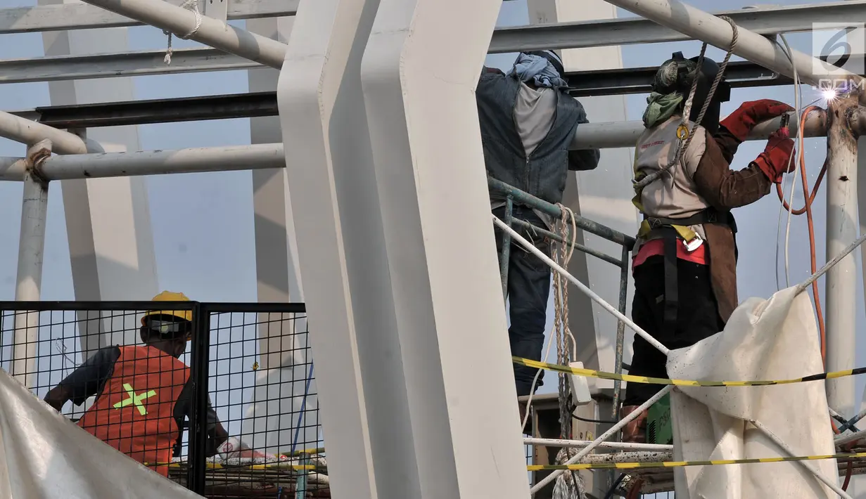 Pekerja menyelesaikan pembangunan Skybridge Stasiun LRT Velodrome-Halte Transjakarta Pemuda, Jakarta, Selasa (11/6/2019). Pengoperasian LRT Kelapa Gading-Velodrome kembali diundur karena belum selesainya pembangunan Skybridge LRT Velodrome-Halte Transjakarta Pemuda. (merdeka.com/Iqbal Nugroho)