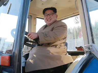 Kim Jong-un saat mengendarai traktor di Kumsong Tractor Factory dalam foto tak bertanggal yang dirilis kantor berita KCNA, (15/11). Traktor buatan dalam negeri ini wujud kemandirian Korut di tengah sanksi internasional. (AFP Photo/Kcna Via Kns/Str)