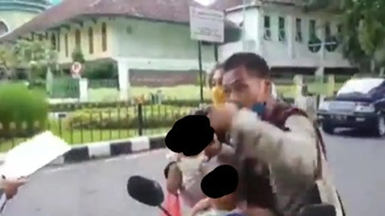 terlihat pasangan suami istri tak mau ditilang petugas kepolisian karena tak menggunakan helm.