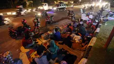 Pemudik menyempatkan beristirahat di pinggir jalan Kota Cirebon karena kelelahan berkendara dari Jakarta, Jumat (24/6). Mereka beristirahat sambil mendinginkan kendaraan bermotor. (Liputan6/JohanTallo)