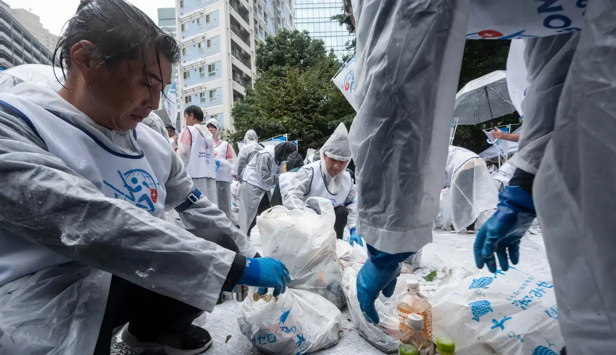 Para kontestan yang terdiri dari tiga tim diharuskan untuk mengumpulkan sampah di area yang telah ditentukan dalam waktu satu jam. (Richard A. Brooks/AFP)