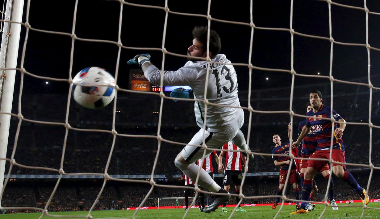 Pemain Barcelona, Luis Suarez, melihat kiper Athletic Bilbao, Iago Herrerin, yang berusaha memblok bola dalam pertandingan leg kedua perempat final Copa del Rey di Stadion Camp Nou, Barcelona, Kamis (28/1/2016) dini hari WIB. (Reuters/Albert Gea)