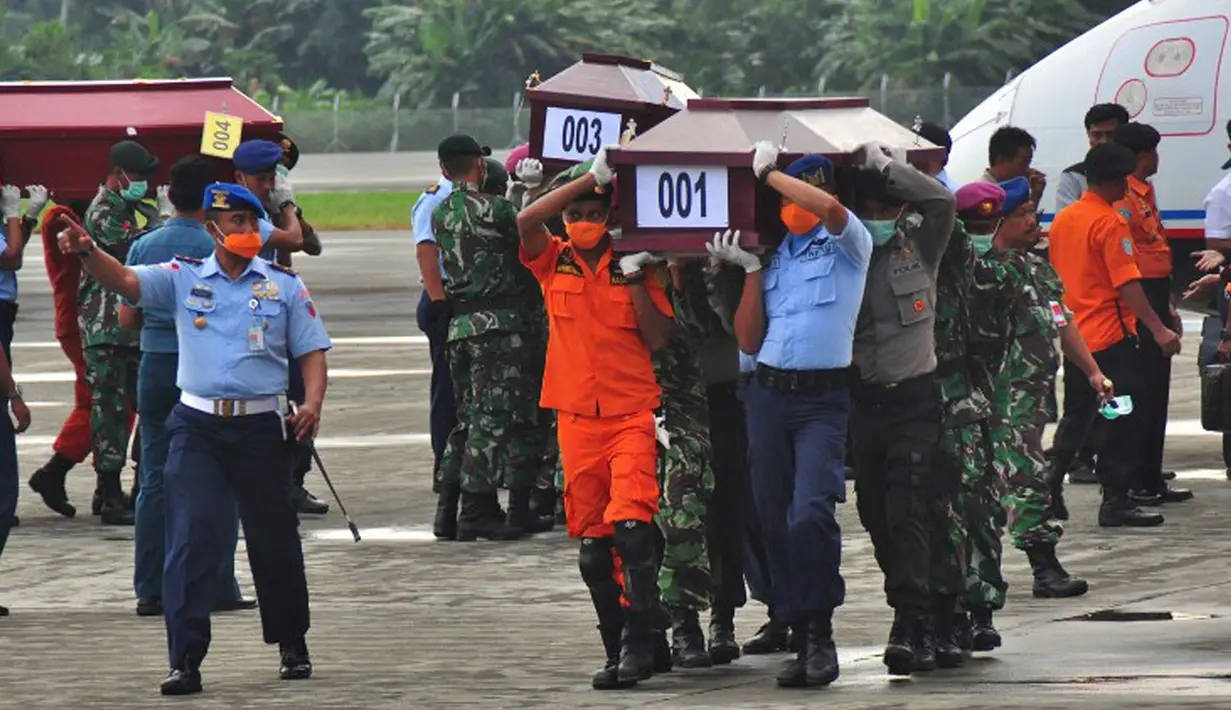 Sejumlah petugas mengangkat peti jenazah korban kecelakaan Trigana Air di Bandara Sentani, Kabupaten Jayapura, Papua, Rabu (19/8). Lima awak dan 49 penumpang menjadi korban kecelakaan pesawat pada 16 Agustus 2015 lalu. (AFP PHOTO/Indrayadi Thamrin)