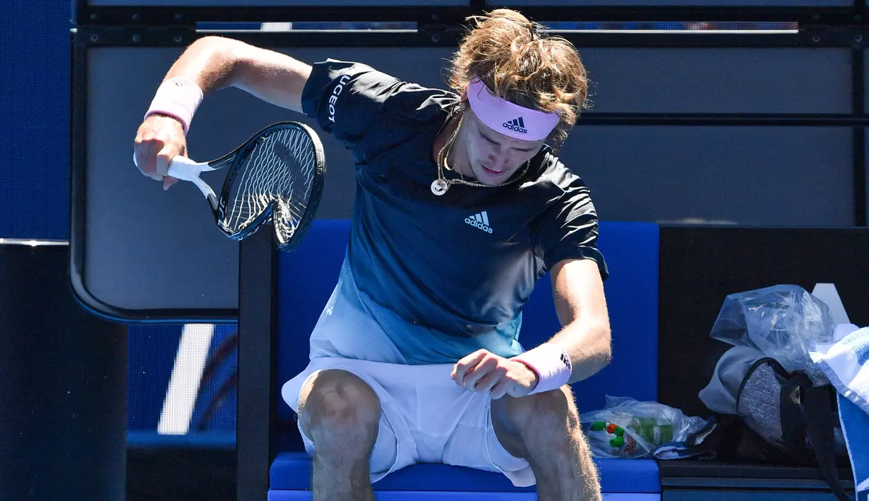 Petenis Jerman, Alexander Zverev membanting raketnya hingga rusak saat beristirahat pada putaran keempat Australia Terbuka  menghadapi Milos Raonic dari Kanada di Melbourne, Senin (21/1). Zverev frustasi setelah kalah dua set 6-1 4-1. (Paul Crock/AFP)