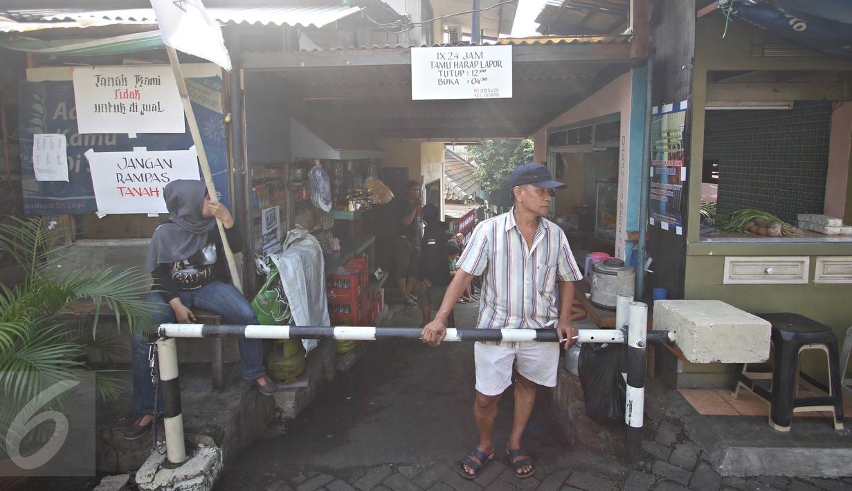 Warga Jalan Lauser, RT 08/08, Kebayoran Baru, Jakarta, menjaga ketat pintu masuk permukiman mereka, Senin (9/5). Penjagaan dilakukan lantaran hari ini diisukan akan ada penyampaian SP-2 terkait penggusuran di lokasi itu. (Liputan6.com/Immanuel Antonius)