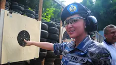 Dewi Perssik menunjuk titik sasaran seusai lomba menembak bersama KSAL Laksamana TNI Ade Supandi, di Lapangan Tembak Mabesal, Cilangkap, Jakarta, Jumat (27/2/2015). (Liputan6.com/Yoppy Renato)