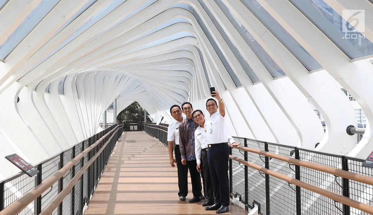 Gubernur DKI Jakarta Anies Baswedan berswafoto saat meresmikan jembatan penyeberangan orang (JPO) di Jalan Jenderal Sudirman, Kamis (28/2). JPO yang diresmikan adalah JPO Gelora Bung Karno dan JPO Bundaran Senayan. (Liputan6.com/Immanuel Antonius)