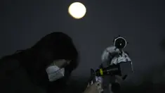 Seorang wanita mengambil foto bulan melalui teleskop saat gerhana bulan di Goyang, Korea Selatan, Selasa, 8 November 2022. Fenomena gerhana bulan total terjadi pada 8 November 2022 di berbagai negara. (AP Photo/Lee Jin-man)