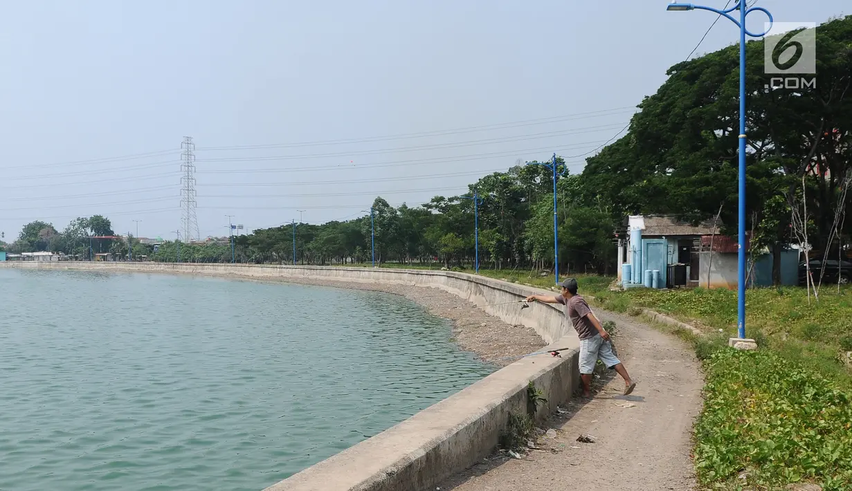 Seorang pria memancing di Waduk Cincin, Jakarta, Selasa (8/1). Pemerintah Kota Administratif Jakarta Utara berencana menata kawasan Hutan Kota Waduk Cincin yang berlokasi di kawasan Sunter, Jakarta Utara. (Liputan6.com/Herman Zakharia)