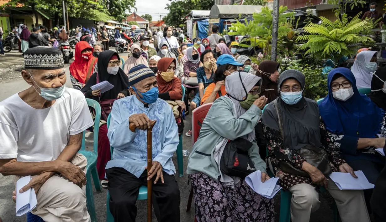 Warga menunggu giliran untuk menerima dosis vaksin booster COVID-19 Pfizer di Surabaya, Jawa Timur, Kamis (13/1/2022). (JUNI KRISWANTO/AFP)