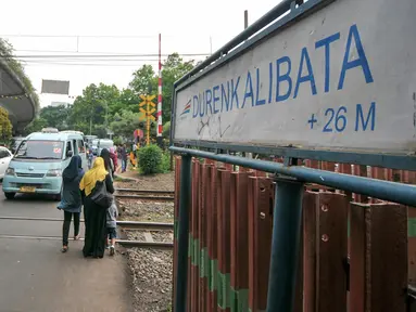 Warga dan pengendara melintas di pintu pelintasan Kereta di Kalibata, Jakarta, (4/12). Pemerintah DKI Jakarta berencana bangun jalan layang atau terowongan di pelintasan-pelintasan sebidang untuk mencegah kecelakaan. (Liputan6.com/Yoppy Renato)