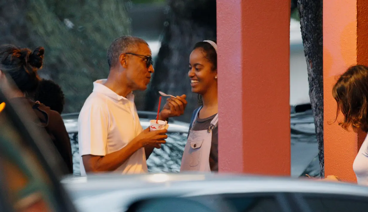 Presiden AS, Barack Obama berbincang dengan putri sulungnya, Malia sambil menikmati es serut saat libur Natal di Kailua, Hawai, AS, (24/12). Obama dan keluarganya akan berlibur selama 17 hari hingga awal Januari 2017. (REUTERS/Kevin Lamarque)