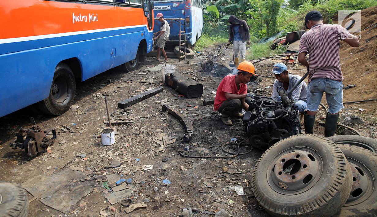 Pekerja memotong bagian mesin dari angkutan Metromini di salah satu pool Metromini, Jalan Pulogebang, Jakarta, Rabu (3/1). Para pengusaha Metromini keberatan terkait kebijakan kelayakan operasional angkutan umum. (Liputan6.com/JohanTallo)