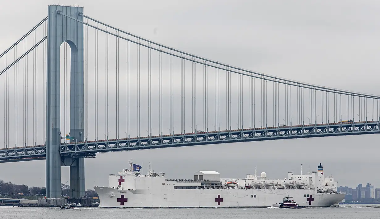 Kapal Rumah Sakit Angkatan Laut USNS Comfort lewat di bawah Jembatan Verrazzano-Narrows dalam perjalanan ke New York, Amerika Serikat, Senin (30/3/2020). Kapal ini memiliki 1.000 tempat tidur dan 12 kamar operasi. (AP Photo/Bebeto Matthews)
