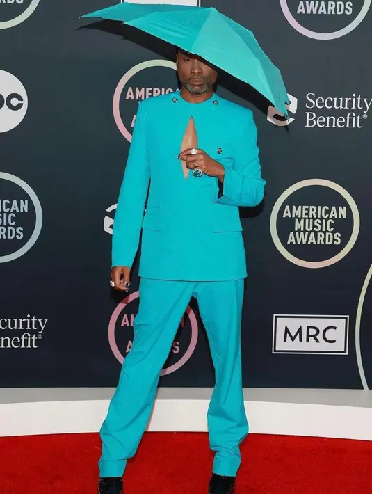 Selain Cardi B, penyanyi sekaligus aktor Billy Porter juga sukses mencuri atensi dengan pilihan warna busana super terang yang dilengkapi aksesori topi menyerupai payung. (Instagram/theebillyporter).