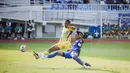 Bek kiri Arema FC, Johan Alfarizi menjuauhkan bola dari kejaran striker Persib Bandung, Uilliam Barros dalam laga pekan keenam BRI Super League 2025/2026 di Stadion Kanjuruhan, Kabupaten Malang, Senin (22/9/2025). (Bola.com/Iwan Setiawan).