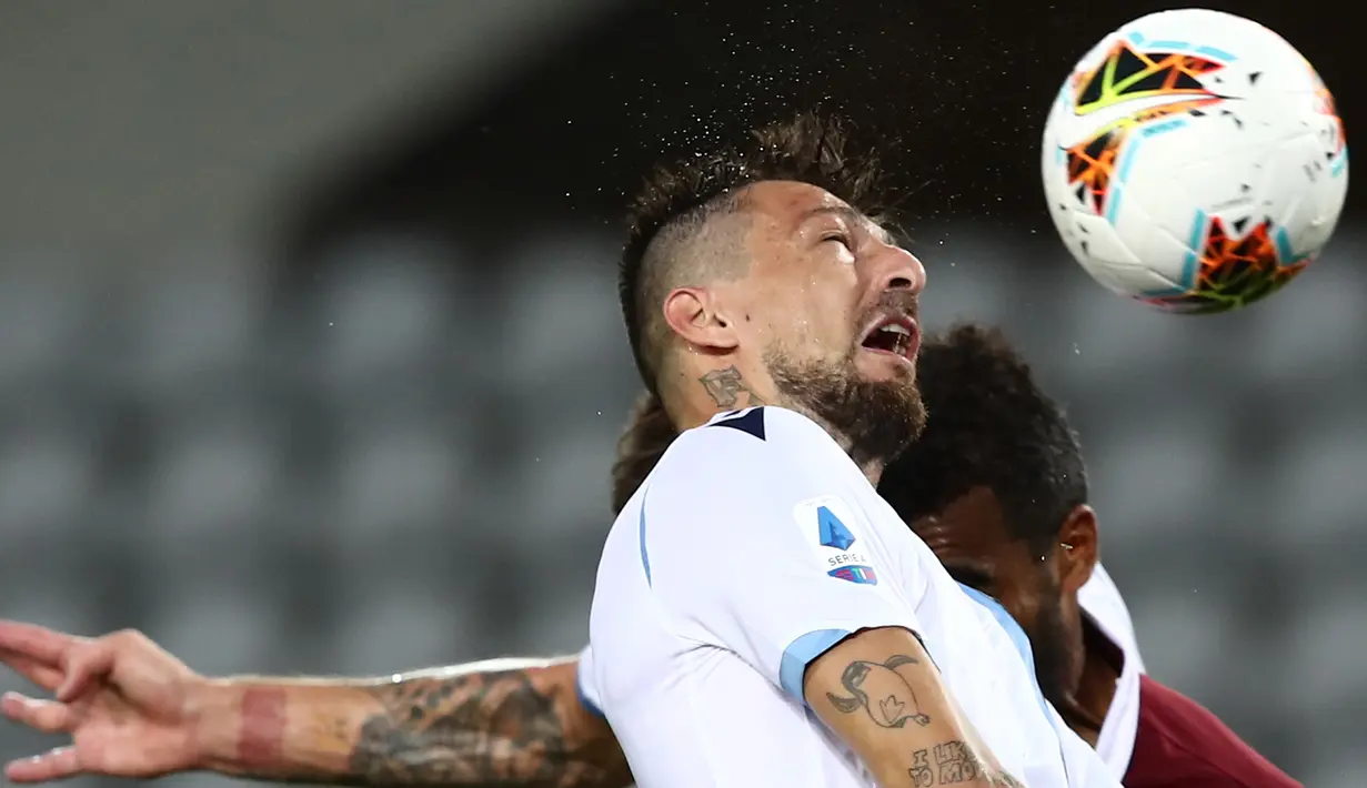 Bek Lazio, Francesco Acerbi berebut bola udara dengan pemain Torino pada pertandingan lanjutan Liga Serie A Italia di stadion Olimpiade di Turin (30/6/2020). Lazio menang tipis atas Torino 2-1. (AFP Photo/Isabella Bonotto)