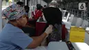 Tenaga kesehatan menyuntikkan cairan vaksin ke penumpang KRL Commterline serta  masyarakat umum  di Stasiun Kota, Jakarta, Rabu (28/7/2021). Vaksinasi disediakan 300 dosis bagi penumpang dan masyarakat umum guna menekan penyebaran Covid-19.  (merdeka.comm/Imam Buhori)