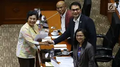 Calon Pimpinan KPK Lili Pintauli Siregar (kiri) berjabat tangan dengan Ketua Komisi III DPR Aziz Syamsuddin usai menerima amplop berisi tema makalah yang harus dibuat, saat uji kelayakan dan kepatutan capim KPK di Kompleks Parlemen, Senayan, Jakarta, Senin (9/9/2019). (Liputan6.com/Johan Tallo)