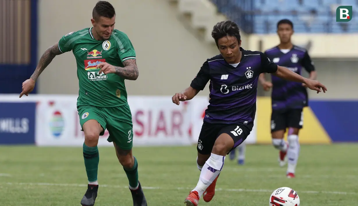 Striker Persik Kediri, Hariyanto S Panto (kanan) dijaga ketat bek PS Sleman, Aaron Michael Evans dalam laga matchday ke-3 Grup C Piala Menpora 2021 di Stadion Si Jalak Harupat, Bandung, Kamis (1/4/2021). Persik Kediri kalah 0-1 dari PS Sleman. (Bola.com/Ikhwan Yanuar)
