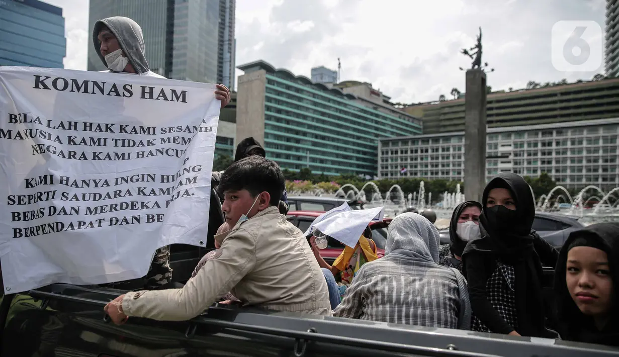 Ratusan imigran Afghanistan jalan kaki menuju Kedubes Kanada di Jakarta, Senin (13/12/2021). Dengan membawa spanduk dan poster, mereka menuntut UNHCR dan IOM segera memproses penempatan mereka ke negara tujuan seperti Kanada, Australia, Selandia Baru maupun AS. (Liputan6.com/Faizal Fanani)