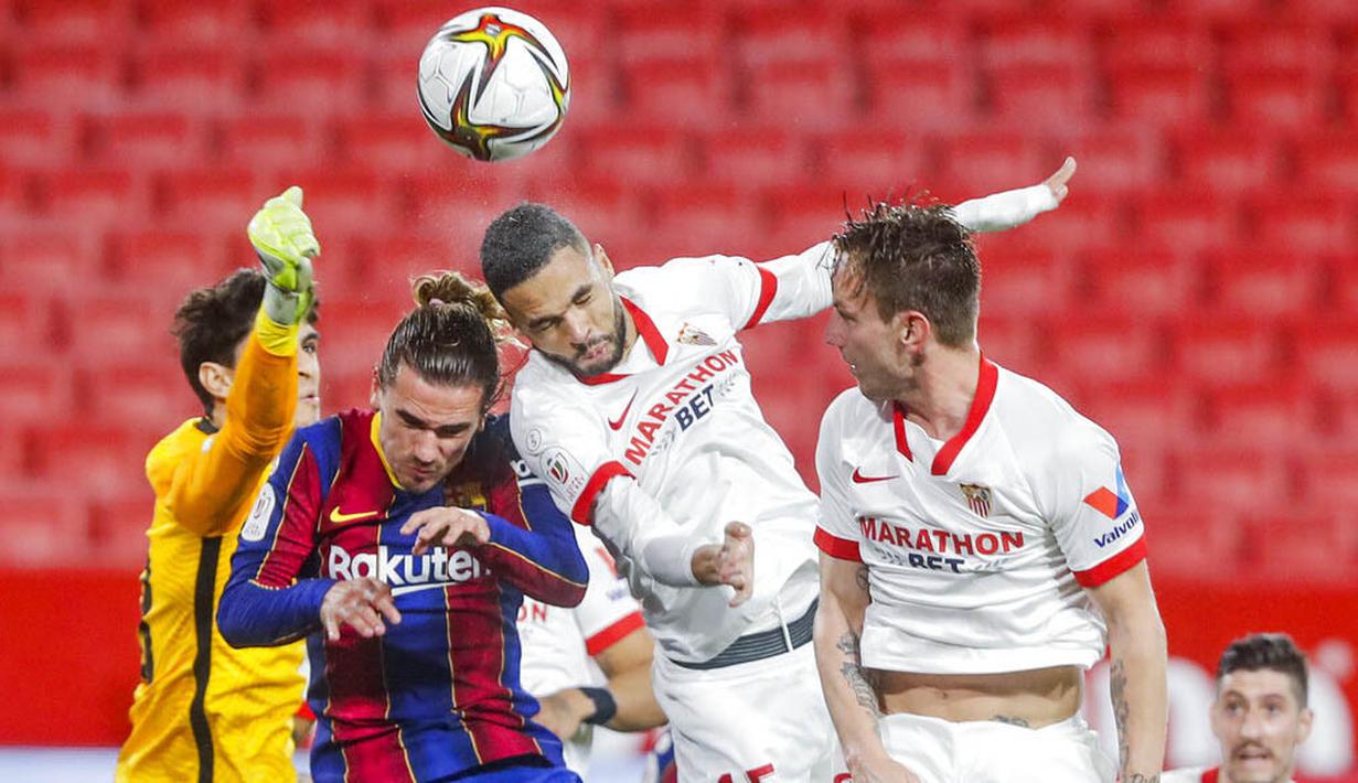 Pemain Sevilla, Youssef En-Nesyri, duel udara dengan pemain Barcelona, Antoine Griezmann, pada laga leg pertama semifinal Copa del Rey di Estadio Ramon Sanchez Pizjuan, Kamis (11/2/2021). Barcelona tumbang dengan skor 2-0. (AP/Angel Fernandez)