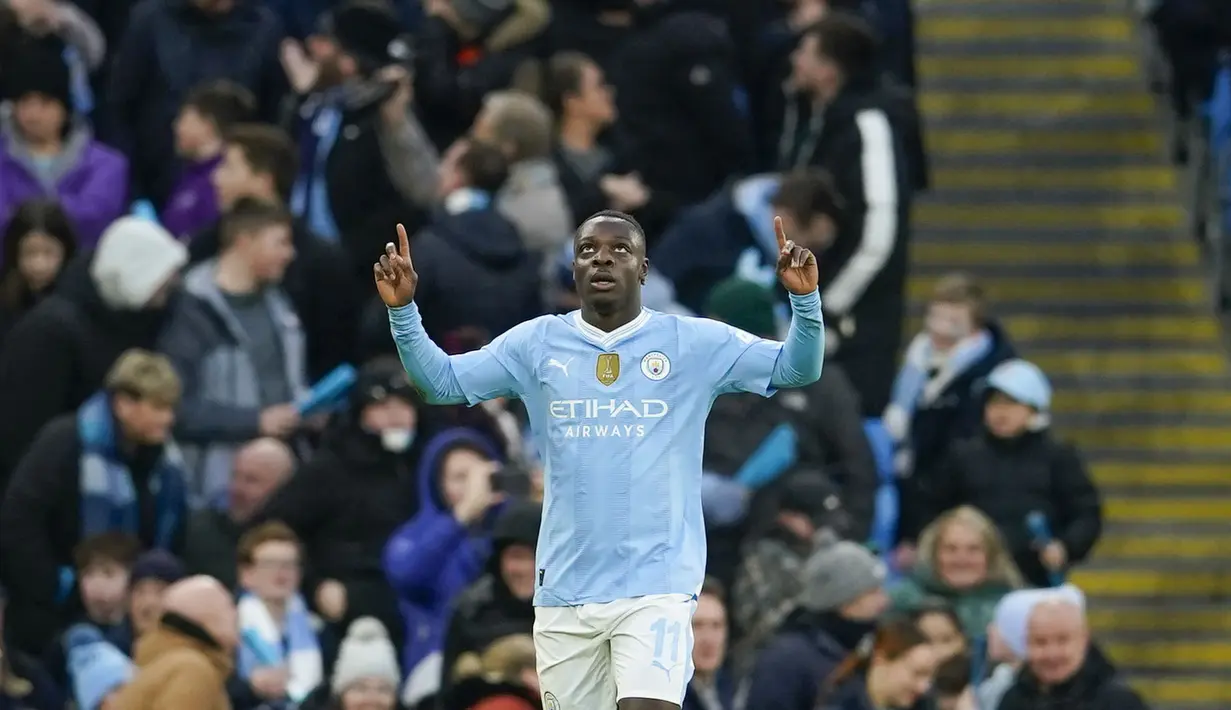 Selebrasi pemain Manchester City, Jeremy Doku, setelah mencetak gol ke gawang Huddersfield Town dalam pertandingan putaran ketiga Piala FA 2023/2024 yang berlangsung di Etihad Stadium, Manchester, Minggu (7/1/2024). Gol Doku tercipta setelah Kevin De Bruyne mengirim umpan silang akurat yang berhasil diselesaikan lewat tendangan langsung. (AP Photo/Dave Thompson)