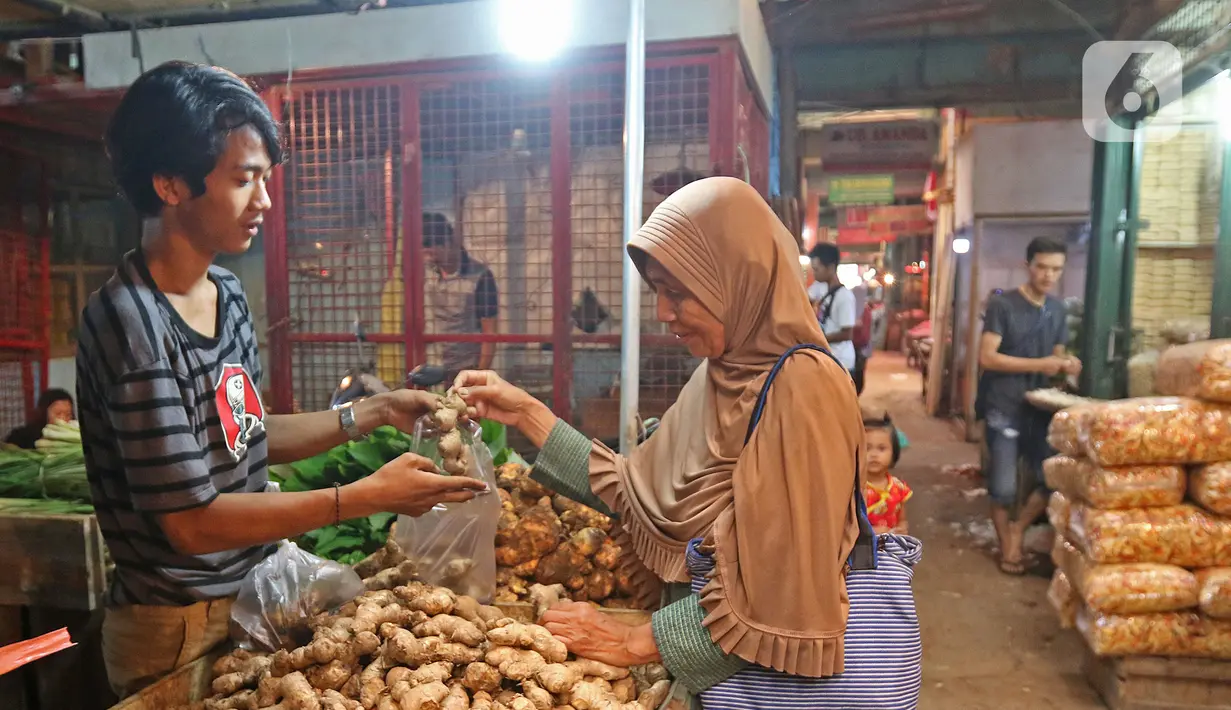 Pedagang melayani pembeli jahe di Pasar Induk Kramat Jati, Jakarta, Kamis (5/3/2020). Harga jahe mengalami kenaikan dari Rp25 ribu perkilogram kini dibanderol Rp35 ribu karena dipercaya mampu menangkal penyebaran virus corona Covid-19 yang sudah masuk Indonesia. (Liputan6.com/Herman Zakharia)