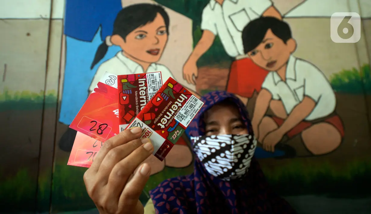 Guru memperlihatkan dua kartu perdana Tri dan Telkomsel beserta kuota gratis yang dibagikan kepada wali murid di SDN Serua Indah I dan II, Ciputat, Tangerang Selatan, Senin (15/9/2020). Program Kartu Perdana itu untuk mendukung kegiatan belajar secara online saat covid-19. (merdeka.com/Dwi Narwoko)