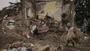 Seorang pria membersihkan puing-puing dari bangunan yang hancur selama pertempuran antara pasukan Rusia dan Ukraina, di luar Kyiv, Ukraina, Jumat, 1 April 2022. Sejak Rusia menginvasi Ukraina pada 24 Februari 2022, kini perang yang berkecamuk memasuki hari ke-37.  (AP Photo/Vadim Ghirda)