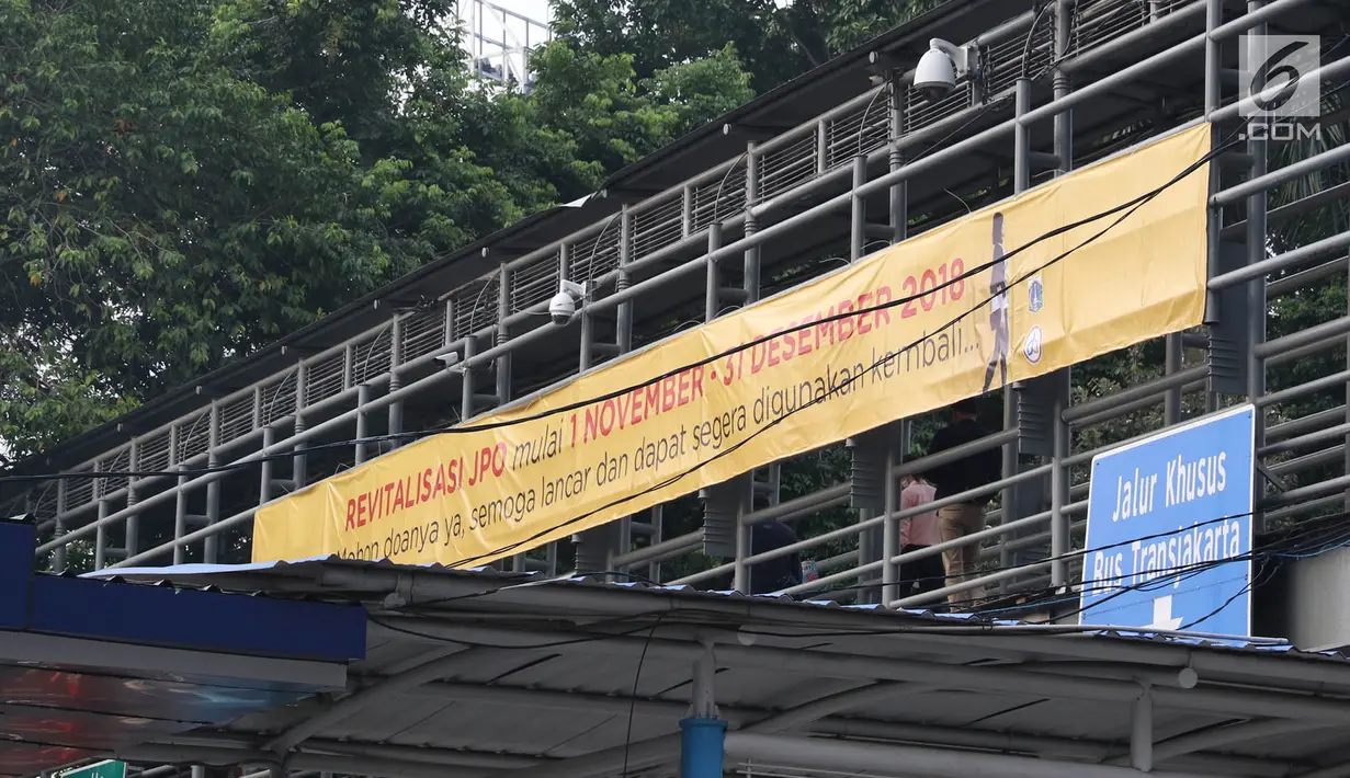Spanduk peringatan revitalisasi Jembatan Penyeberangan Orang (JPO) di JPO Jalan Sudirman, Jakarta, Selasa (6/11). Ketiga JPO yang akan direvitalisasi mendapatkan penambahan lift dan CCTV. (Liputan6.com/Immanuel Antonius)