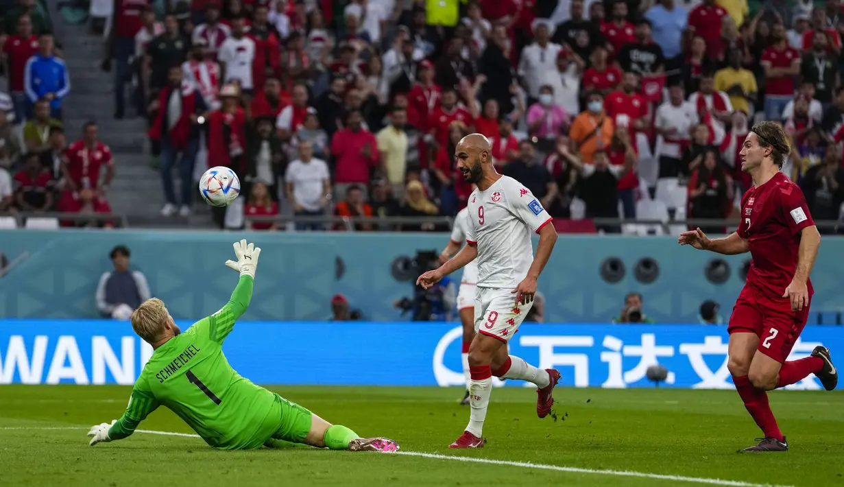 Kiper Denmark, Kasper Schmeichel berusaha menyelamatkan bola dari tendangan penyerang Tunisa, Issam Jebali selama pertandingan grup D Piala Dunia 2022 Qatar di Education City Stadium di Al Rayyan, Qatar, Selasa (22/11/2022). Dengan demikian, kedua tim sama-sama mengumpulkan satu poin di Grup D. (AP Photo/Manu Fernandez)