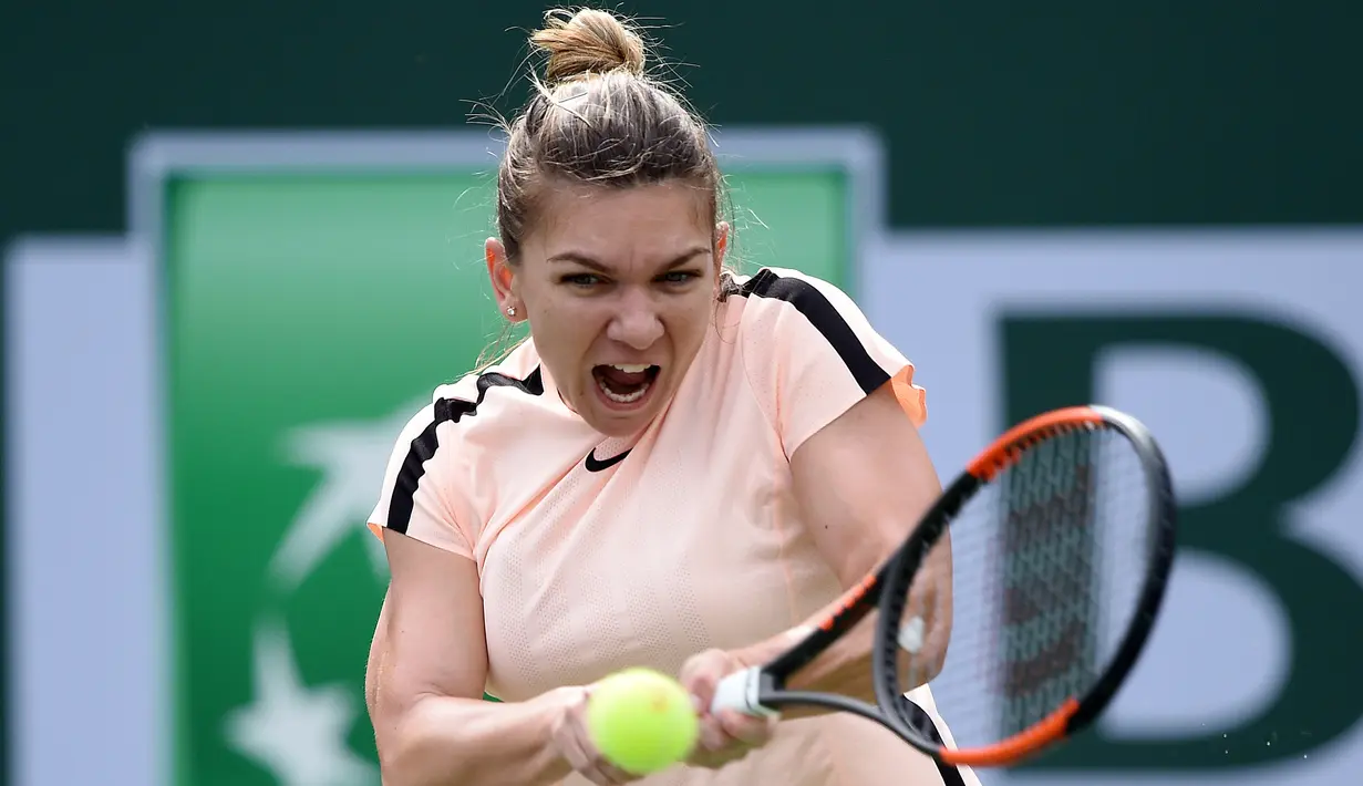 Petenis Rumania, Simona Halep mengembalikan bola ke petenis Cina, Wang Qiang pada turnamen BNP Paribas Terbuka di Indian Wells, Selasa (13/3). Halep sukses meraih tiket perempat final dan akan menghadapi Petra Martic. (Kevork Djansezian/Getty Images/AFP)