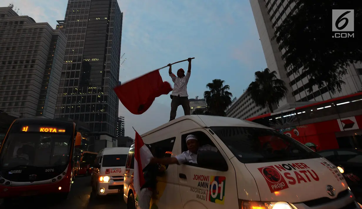 Pendukung capres-cawapres 01 Jokowi-Ma'ruf Amin berkeliling di kawasan Bundaran HI, Jakarta, Rabu (17/4). Berdasarkan hasil hitung cepat  Pasangan Jokowi-Ma'ruf Amin unggul diberbagai lembaga survei. (Merdeka.com/Imam Buhori)