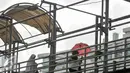 Dua orang wanita melintasi jembatan penyeberangan orang (JPO) di Mampang, Jakarta, Selasa (17/1). Warga berharap pihak berwenang bisa segera memperbaiki JPO demi keamanan dan kenyamanan pengguna. (Liputan6.com/Yoppy Renato)