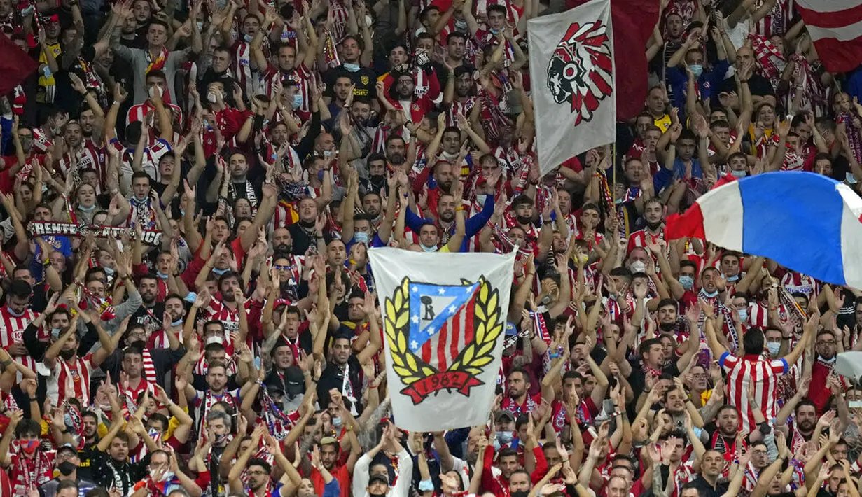 Suporter Atletico Madrid mendukung timnya saat bertanding melawan Barcelona pada pertandingan lanjutan La Liga Spanyol di Estadio Wanda Metropolitano di Madrid, Minggu (3/10/2021). Atletico Madrid kini berada di urutan kedua klasemen dengan 17 poin. (AP Photo/Manu Fernandez)