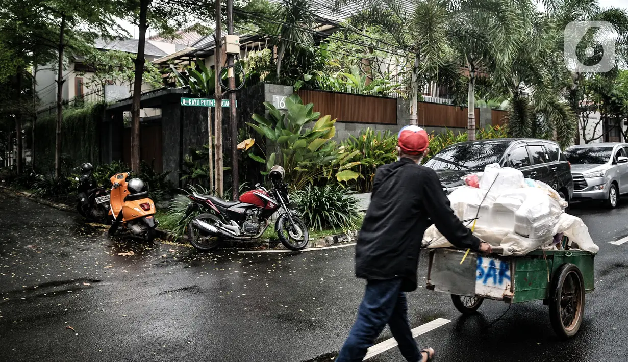 Pemulung melintas di depan kediaman Ihsan Yunus saat digeledah KPK di kawasan Kayu Putih, Pulogadung, Jakarta, Rabu (24/2/2021). Dalam penggeledahan tersebut KPK mengerahkan 10 penyidik dan membawa dua koper saat keluar dari kediaman Ihsan Yunus. (merdeka.com/Iqbal S. Nugroho)