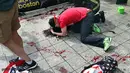 Seorang pria memeluk korban BomBoston di area penonton Maraton.