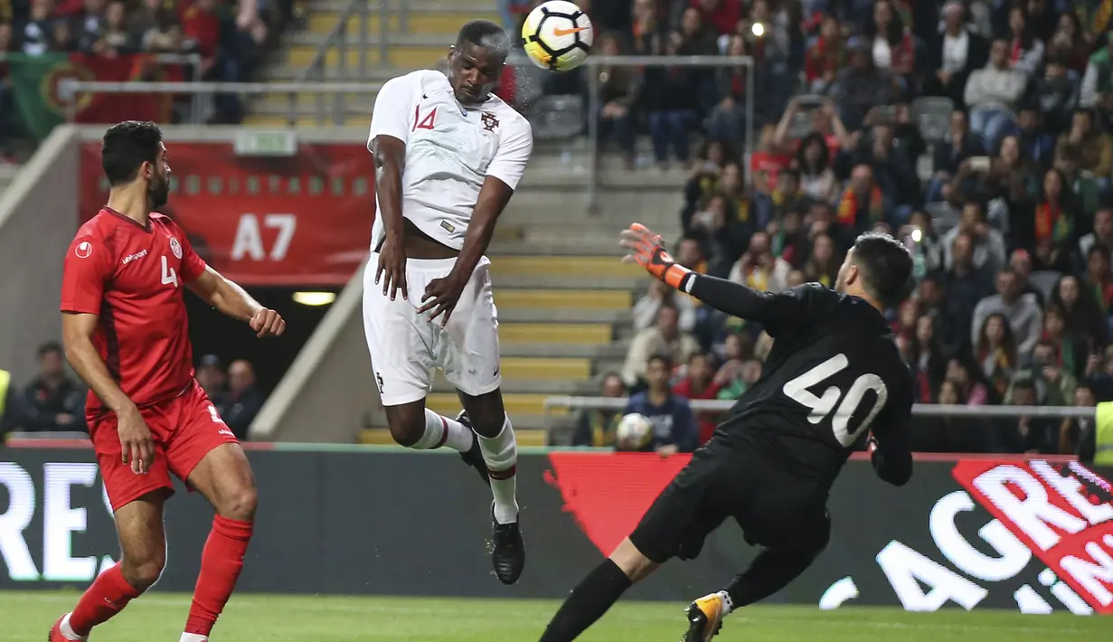 Aksi pemain Portugal, William Carvalho (tengah) melakukan sundulan ke gawang Tunisia pada laga uji coba di Estadio Municipal de Braga, (28/5/2018) waktu setempat. Portugal dan Tunisia bermain imbang 2-2. (AP/Luis Vieira)