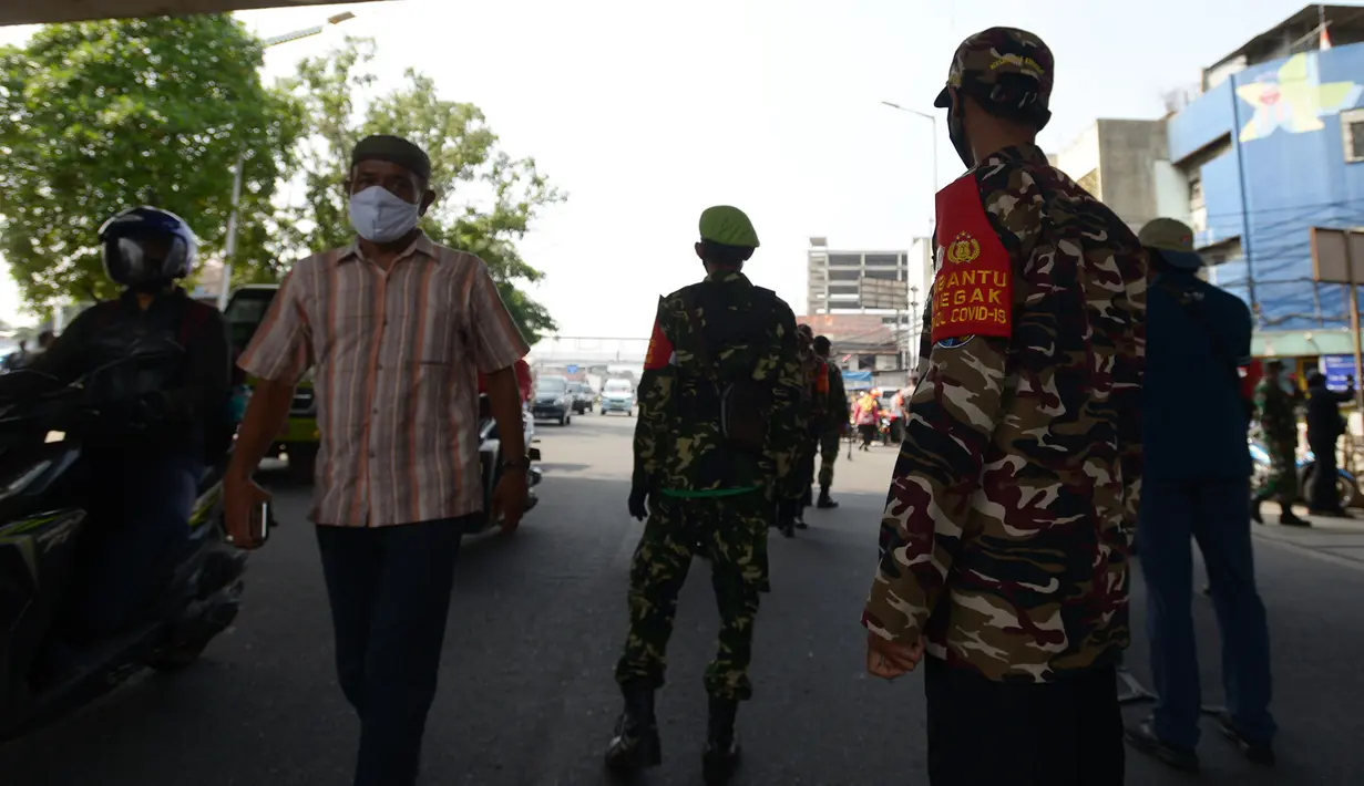 Anggota Organisasi Kemasyarakatan atau Ormas membantu Satpol PP dalam Operasi Yustisi Protokol Kesehatan Covid-19 di Terminal Kampung Melayu, Jakarta, Kamis (24/9/2020). Operasi Yustisi untuk menegakkan disiplin dalam penerapan protokol kesehatan itu melibatkan Ormas. (merdeka.com/Imam Buhori)