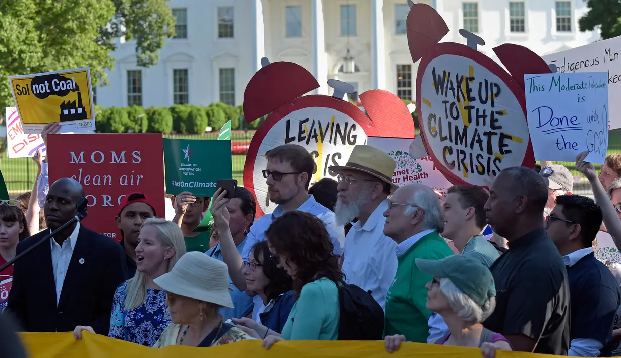 Demonstran berkumpul di dekat Gedung Putih di Washington, AS, Kamis (1/6). Demonstran memprotes keputusan Donald Trump yang menarik AS dari perjanjian Paris tentang perubahan iklim yang disepakati pada 2015. (AP/ Susan Walsh)