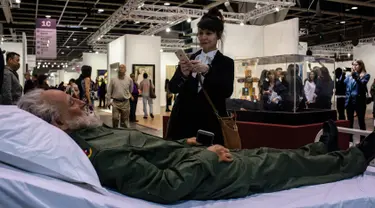 Seorang pengunjung mengambil foto replika Fidel Castro yang merupakan karya seniman Tiongkok dalam pameran Art Basel di Hong Kong (22/3). Dalam pameran ini, banyak karya yang ditampilkan, seperti lukisan dan instalasi eksperimental. (AFP/Anthony Wallace)