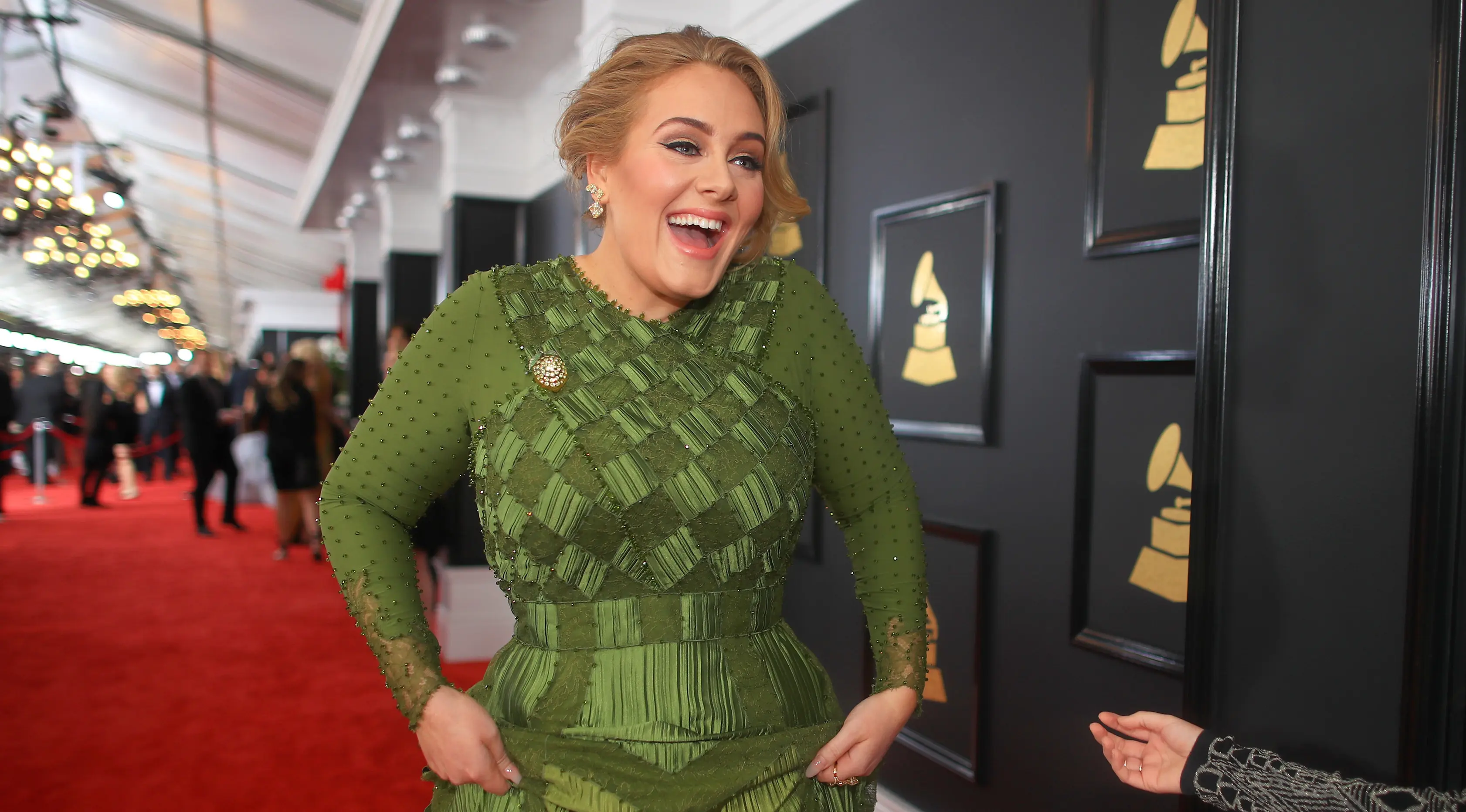 Penyanyi Inggris, Adele tertawa sambil berjalan di karpet merah Grammy Awards 2017 di Los Angeles, Minggu (12/2). Di Grammy Awards ini, Adele bersaing ketat dengan para musisi lainnya di lima kategori. (CHRISTOPHER POLK/GETTY IMAGES NORTH AMERICA /AFP)